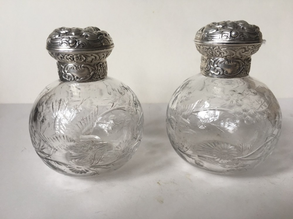 a pair of silver topped hm perfume bottles