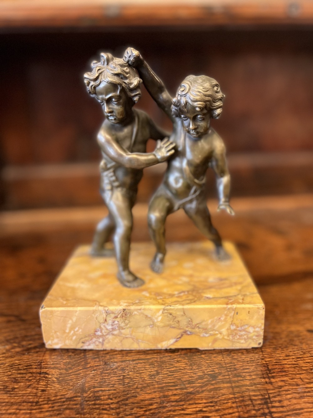 bronze group of fighting cherubs on sienna marble base