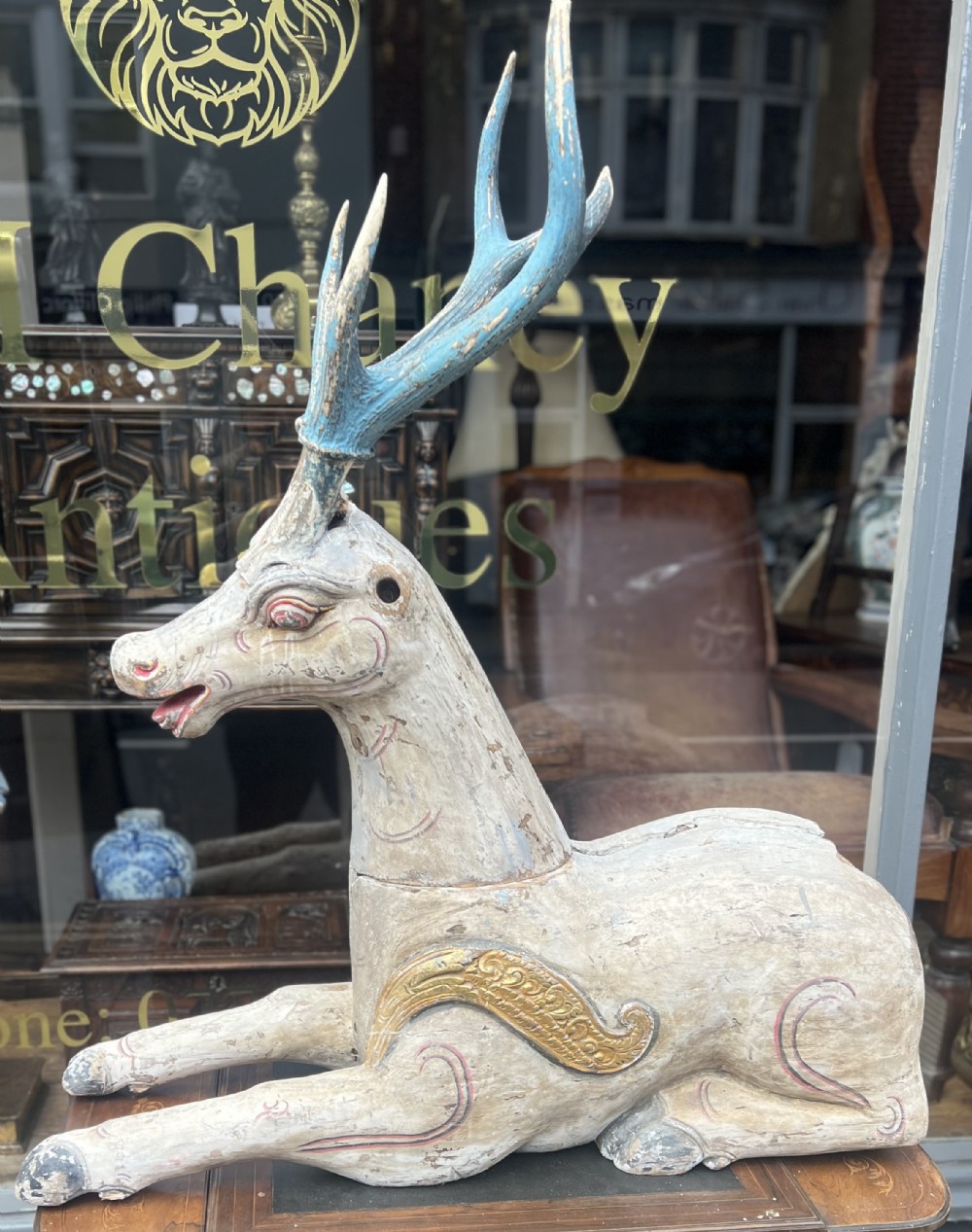 large carved wooden stag in seated position