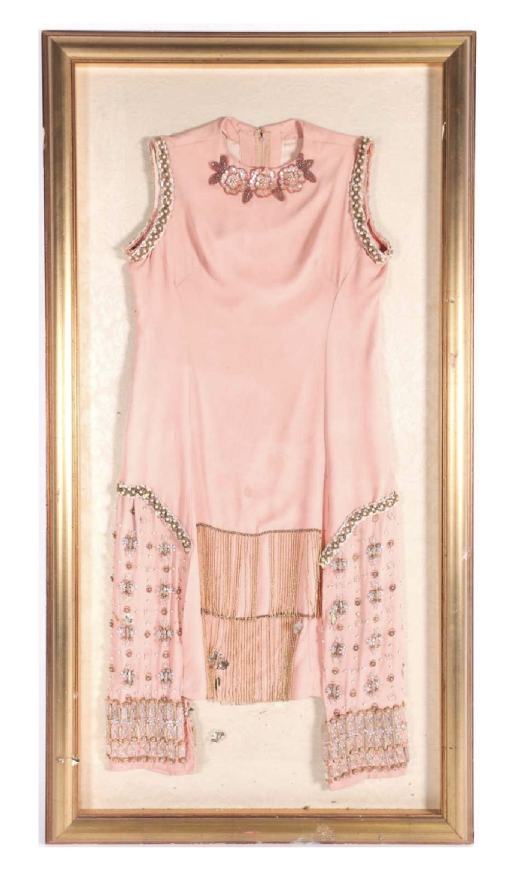 a 1920s salmon pink flapper dress in a gilt frame