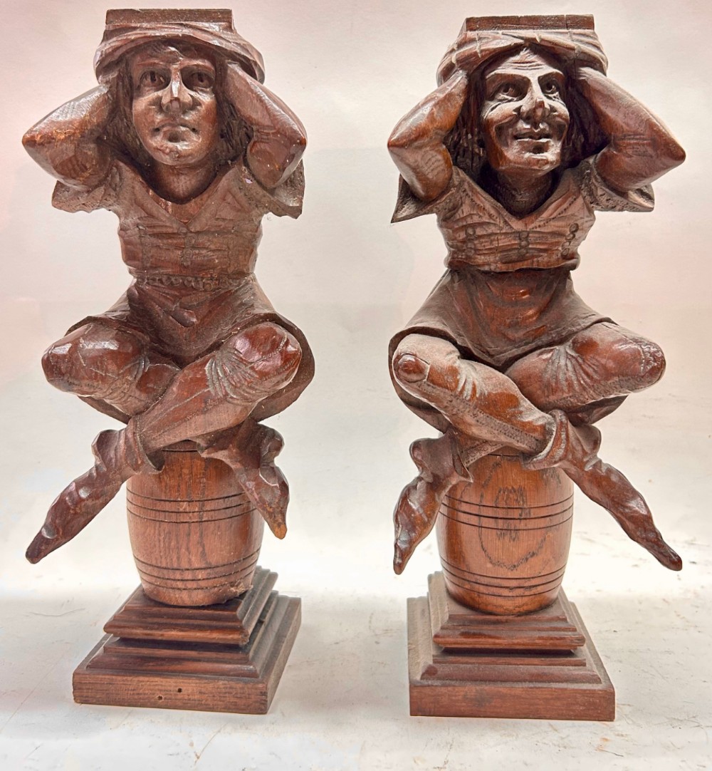 c19th carved figures of jesters sitting on barrels